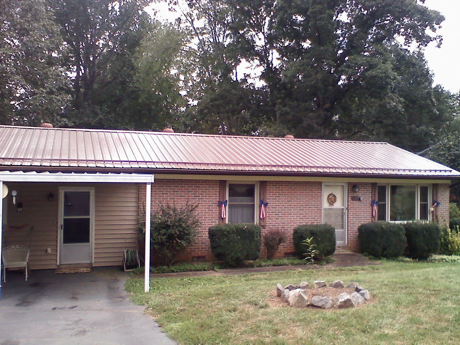 Bronze metal roof and carport on a brick ranch home — Roof Repair work by our crew in Fallsburg